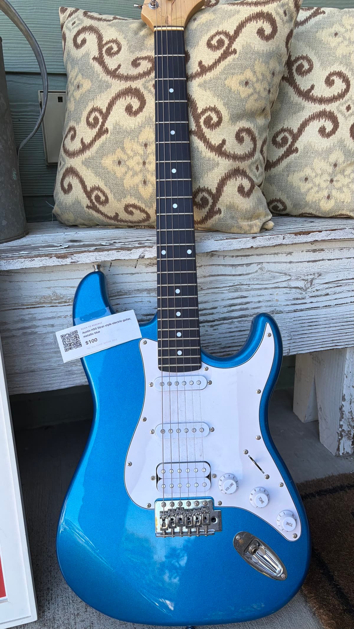 Blue electric guitar with Available!™ hangtag attached